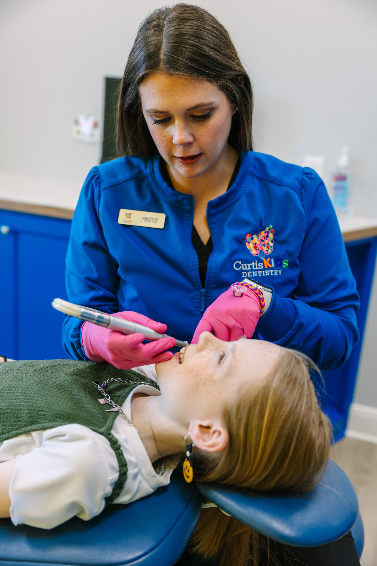 Dental hygenist cleaning a child's teeth