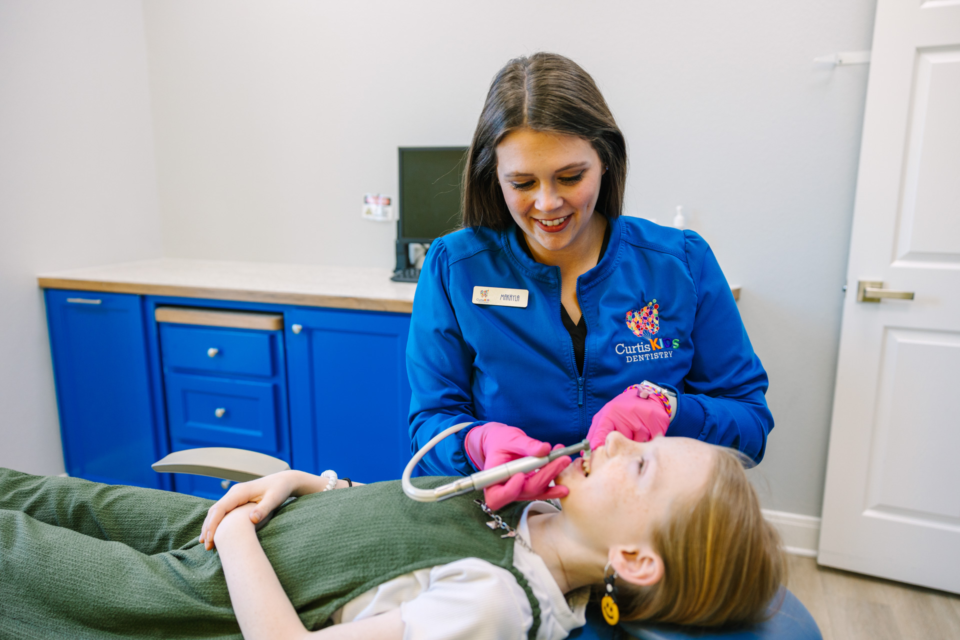 Caring dental hygenist working on a child's teeth