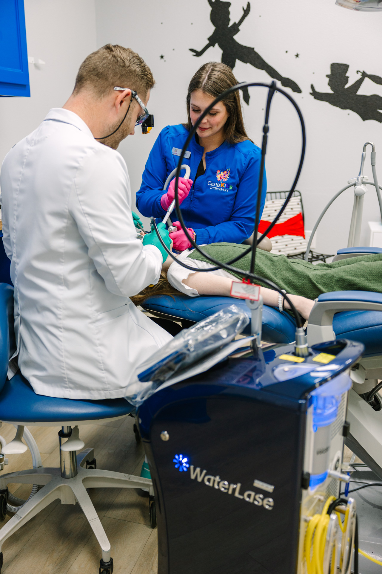 Dr. Curtis and assistant performing restorative dentistry on a child patient