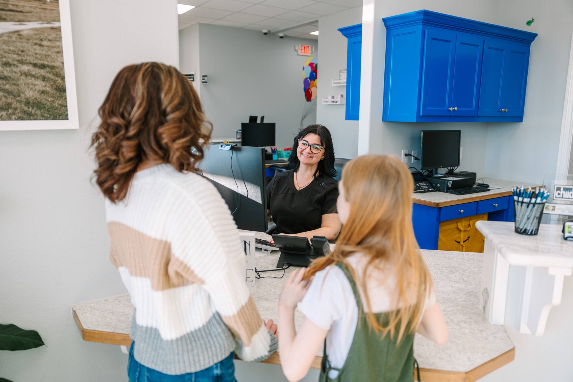 Receptionist checking in patients at front desk